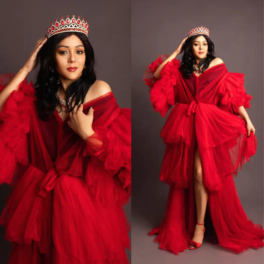 Woman in a red dress with ruffled layers and a tiara against a gray background