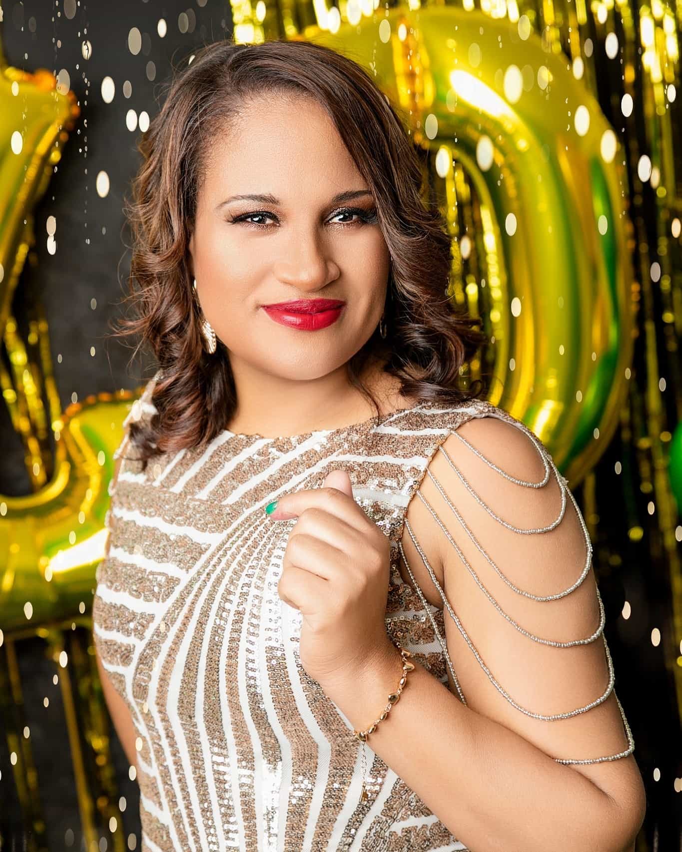Woman in a sparkly dress with gold balloons in the background