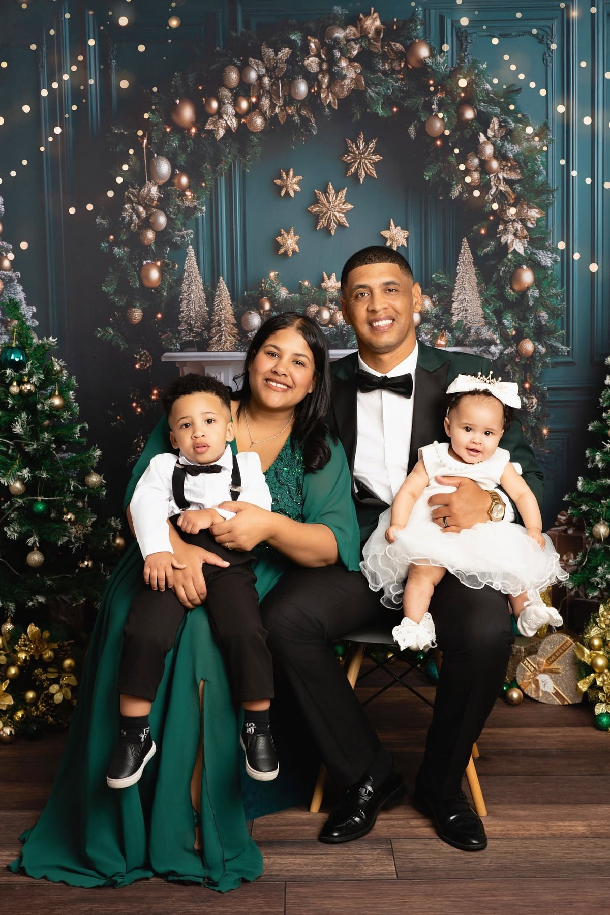 Family sitting Infront of a Christmas Background for Family pictures