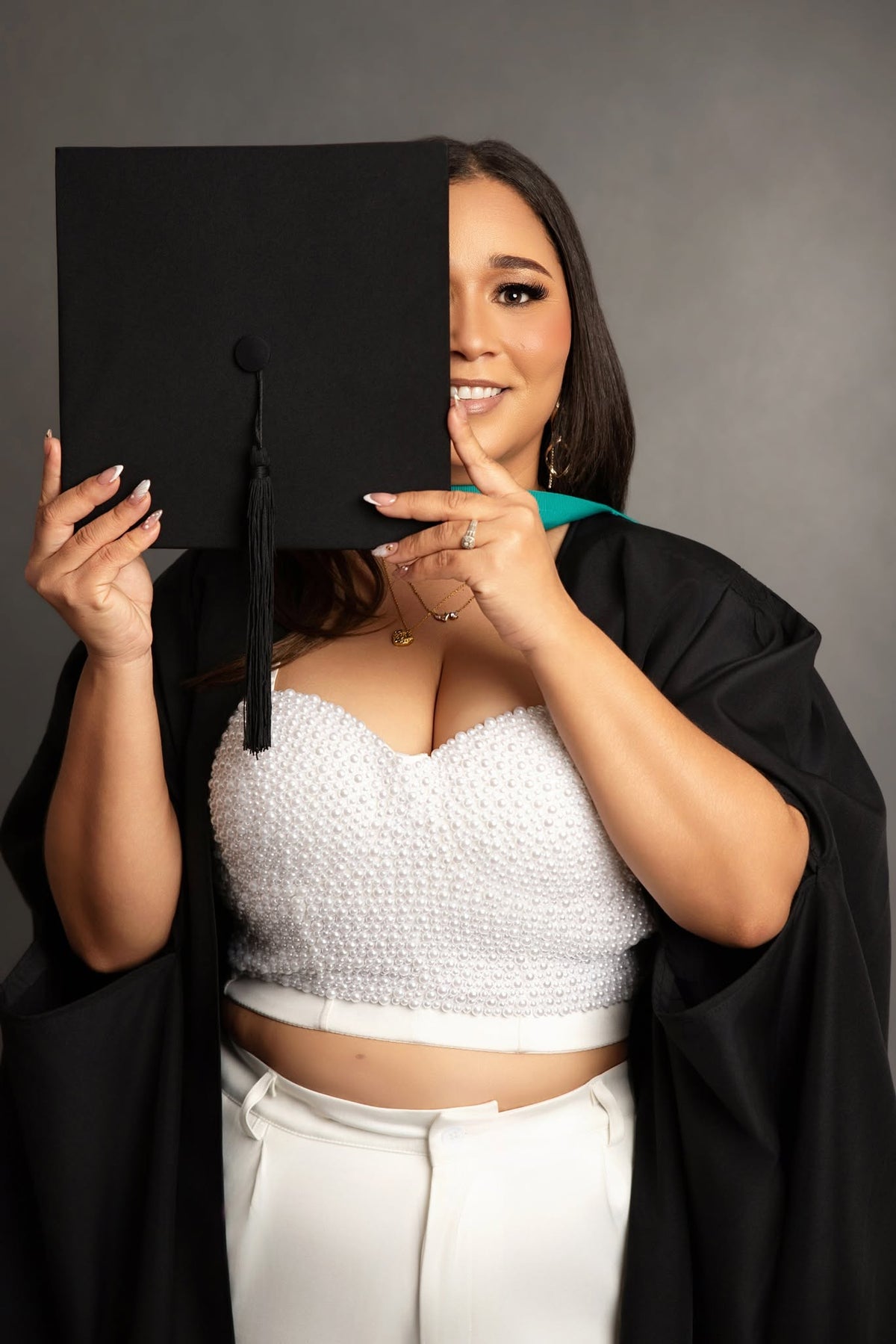 Graduate wearing a graduation cap and gown during a professional studio photoshoot in Cape Town.