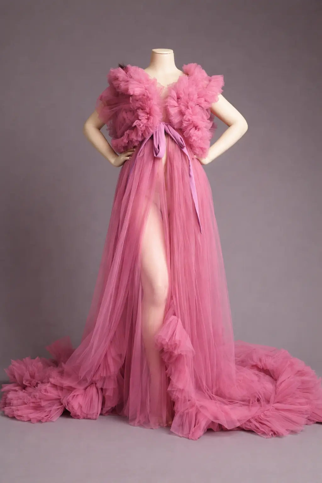 Pink evening gown with floral details on a mannequin against a gray background