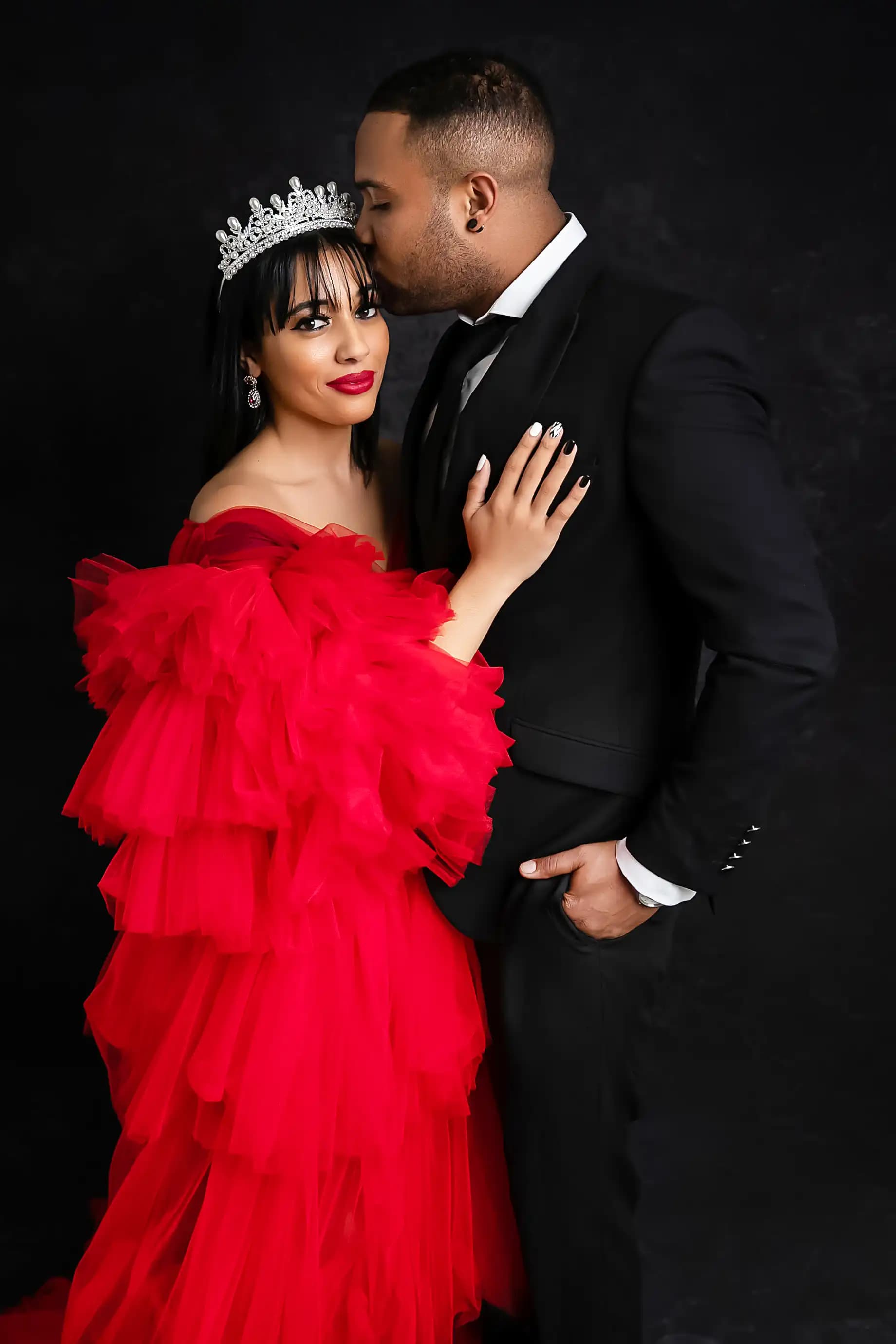 Couple sharing a power couple pose against a black background