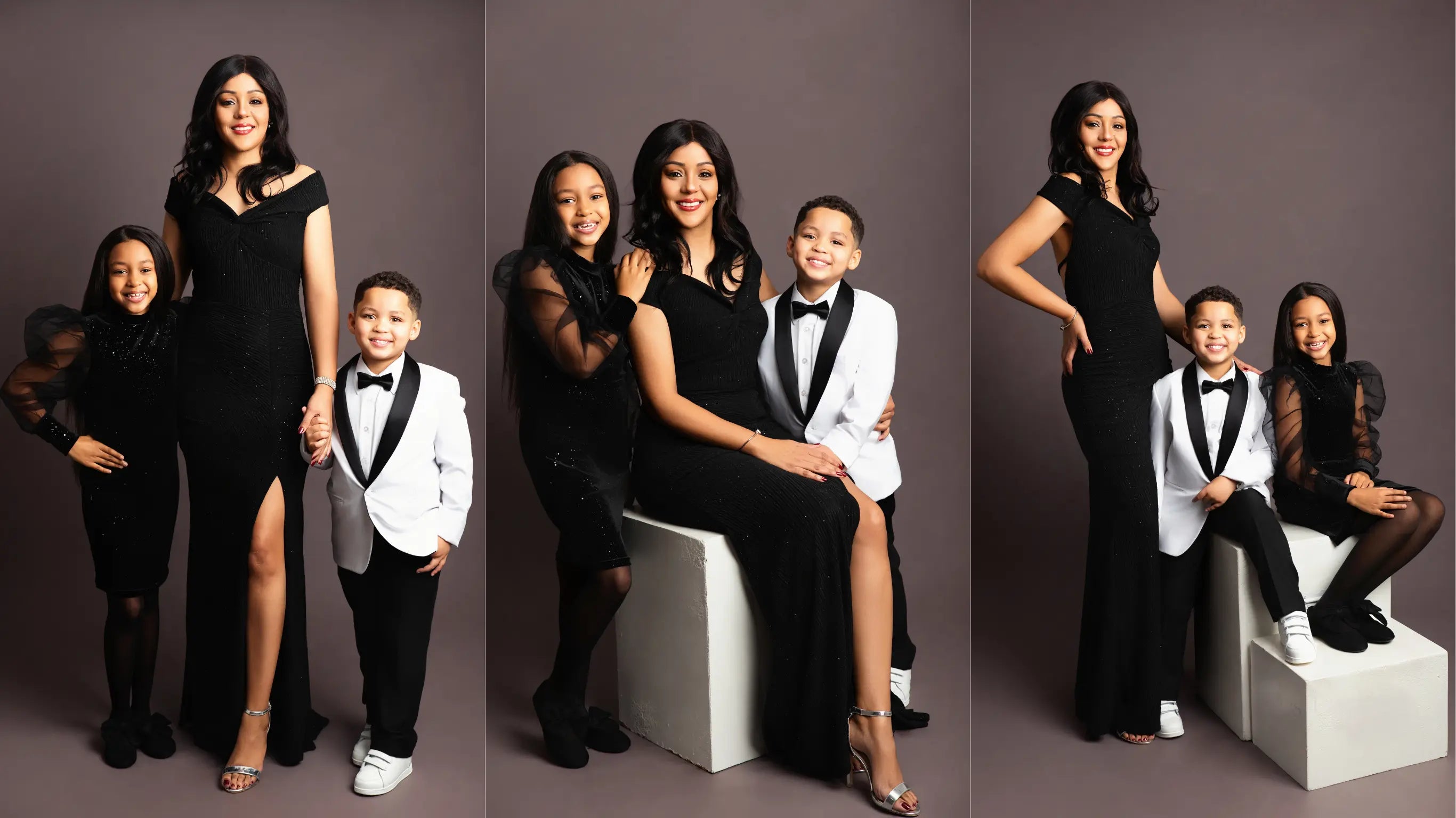 Woman in a black dress with children in formal attire against a gray background